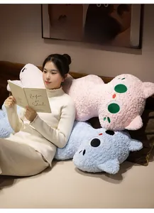 Close-up of pink and blue long plush cat pillows in a cozy bedroom home setting