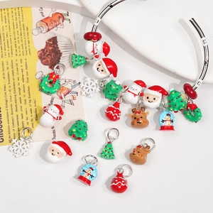 Flat lay of Christmas DIY charms including Santa Claus and snowman on a silver bracelet