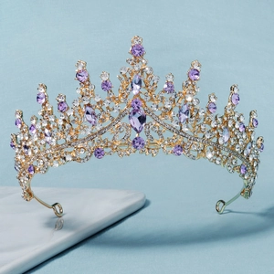 Detailed macro view of purple crystals and white rhinestones on a gold tiara crown