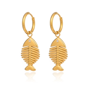 Dettaglio di orecchini a lisca di pesce d'oro con cristalli su sfondo bianco
