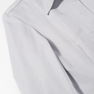 Detail of light gray blazer showing notched lapel, breast pocket, and fine fabric texture