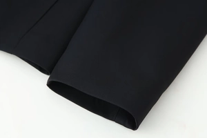 Detailed close-up of the black V-neck jacket sleeve showing fine fabric texture and stitching