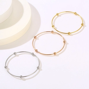 Minimalist stainless steel bangle with metallic beads in gold, silver, and rose gold