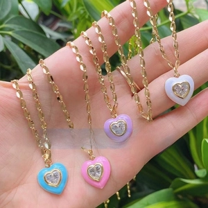 Detail of five colorful enamel heart pendants with inset zircon on a gold chain