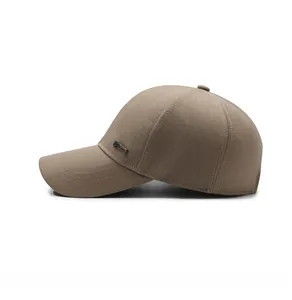 Close-up of khaki baseball cap side with detailed fabric texture and metal logo plate