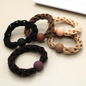 Detail of woven elastic hair ties with matte beads in neutral earth tones colors
