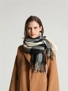 Close-up of black, white, and grey checkered scarf with fringe tassels and soft texture
