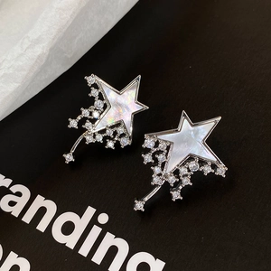 Star-shaped silver needle earrings with shimmering mother-of-pearl and zircon accents