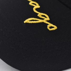Macro shot of yellow script embroidery detail on high-quality black cotton baseball cap