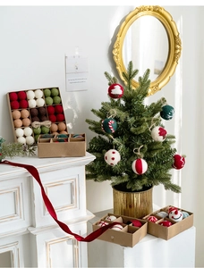 Christmas wool felt ball ornaments with festive patterns displayed on a mantelpiece