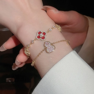 Detail view of 18k gold-plated bracelets featuring red clover and pink zircon gourd