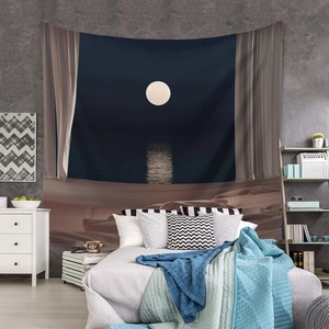 Detail of bohemian tapestry featuring a moonlit desert landscape over a modern bed