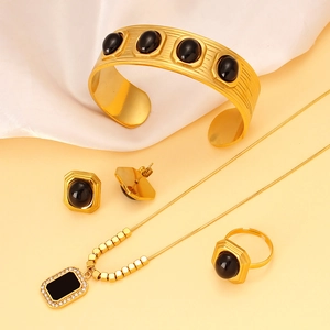 Dettaglio del set di gioielli in oro 18K con pietre nere naturali e motivi quadrati