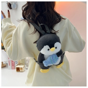 Detailed view of plush penguin backpack with small blue fish on model back