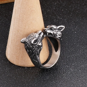 Macro view of double wolf head ring in vintage silver on a wooden display stand