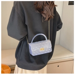 Close-up of a lilac quilted jelly bag with gold chain strap worn cross-body style