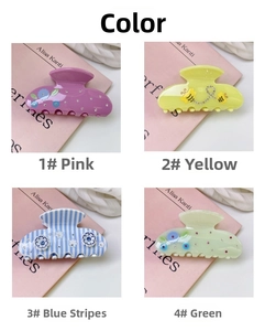 Detail of four acetate hair claws with bee and flower motifs featuring small rhinestones