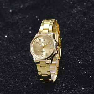 Close-up of gold alloy steel watch band with numeric dial on black textured background