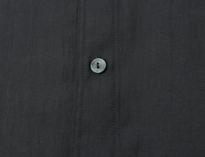Close-up of the stitching and button detail on a dark grey poplin casual shirt