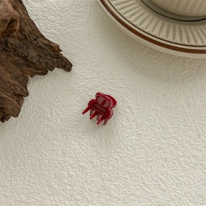 Détail d'une mini pince à cheveux rouge en résine avec inscription dorée FRANCE Handmade