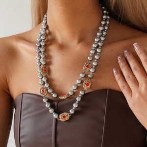 Detail einer Vintage Doppelperlenkette mit grauen Perlen und rotem Edelstein-Zierstück
