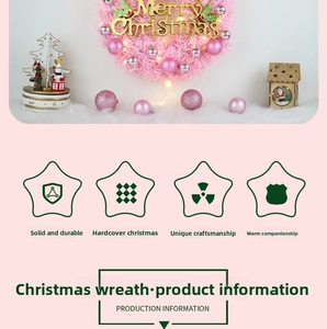 Pink Christmas wreath with Merry Christmas sign, LED lights and ornaments on a white door