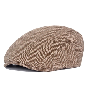 Close-up of brown and white herringbone wool blend newsboy cap with classic flat texture