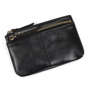 Detail view of the black genuine leather coin purse showing two brass zipper pockets and textures