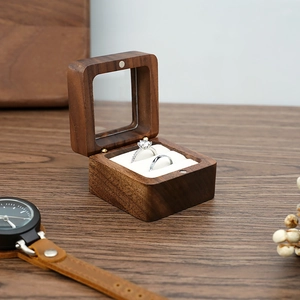 Detail of walnut wood double ring box with clear window and white velvet inserts