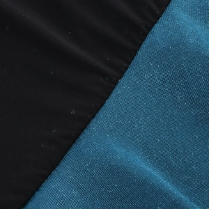 Dettaglio ravvicinato di velluto nero e tessuto blu a nido d'ape sull'abito da sera