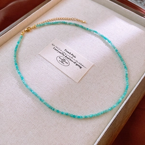 Close-up of sky blue faceted bead necklace with golden lobster clasp and extension chain