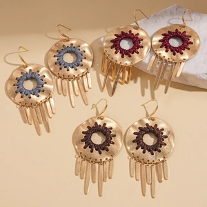 Three pairs of gold geometric hoop earrings with woven centers and metallic tassels