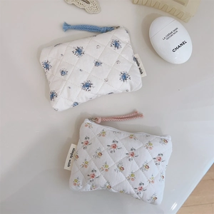 Détails de mini pochettes en coton matelassé avec motifs floraux et fermetures éclair
