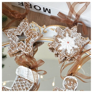 Macro detail of gingerbread style star and snowflake resin ornaments on a mirror tray