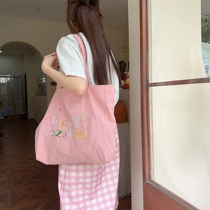 Détail du sac cabas en toile rose avec broderie arc-en-ciel Lucky sur l'épaule