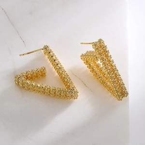 Textured 18K gold-plated irregular V-shaped geometric earrings on marble surface