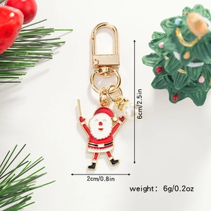 Detailed macro shot of a Santa Claus metal keychain with red enamel and pearl accents