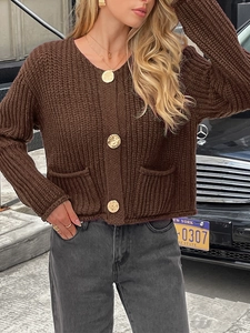 Détail du cardigan en maille marron foncé avec col en V et boutons dorés élégants