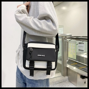 Detail of crossbody bag with flip-top cover and dual buckle closures in urban setting