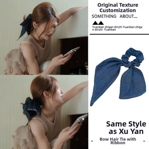 Detail of blue denim bow hair scrunchie with long ribbons for elegant hairstyling