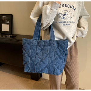 Détail du grand cabas en jean matelassé bleu au design décontracté et texture douce