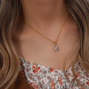 Golden leaf eye necklace with marquise cut zircon pendant on model neck closeup