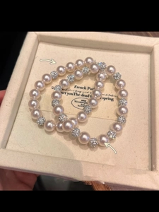 Macro detail of elegant double-layer pearl bracelets with pavé-set cubic zirconia beads