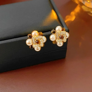 Macro shot of vintage pearl flower earrings with zircon and tiger eye on a jewelry box
