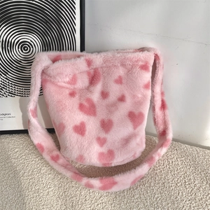 Detailed texture of pink plush faux fur shoulder bag with red heart pattern print