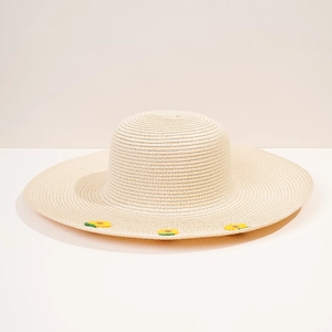 Dettaglio di ricamo a girasole su cappello di paglia bianco a tesa larga per l'estate