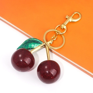 Detail of red glitter cherry keychain with green leaf and golden metal lobster clasp