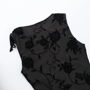 Detail of sheer black mesh fabric featuring intricate velvet flocked rose patterns