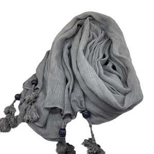Gray voile scarf featuring handmade tassels and navy blue beaded charms on white background