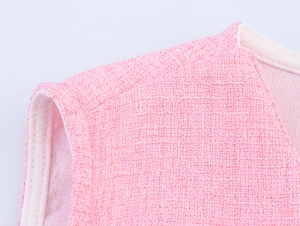 Nahaufnahme der rosa Tweed-Weste mit feiner Webstruktur und hochwertiger Kantenverarbeitung